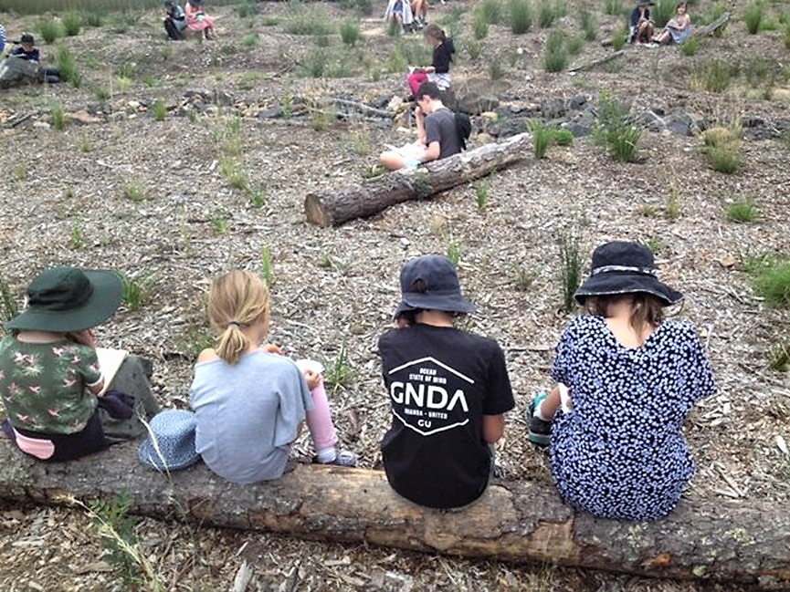 Students sitting in Indigenous Garden